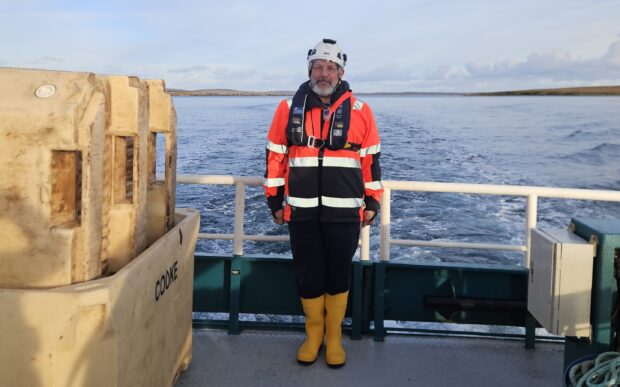 Maritime and Coastguard Agency (MCA) Investigator, Paul Atkins, on board a vessel wearing safety uniform.