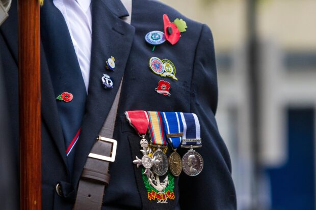 Four Military medals pictured on a person wearing a suit.