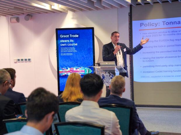 A person in a suit presenting to a crowd.